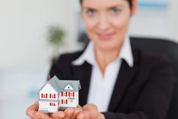 Businesswoman holding a miniature house — Stock Photo, Image