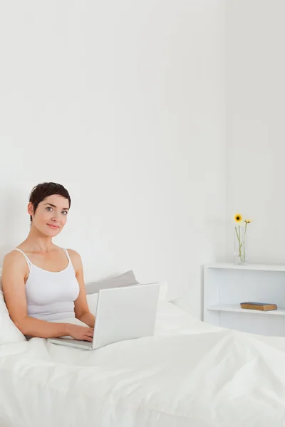 Portrait of a beautiful brunette using a laptop — Stock Photo, Image