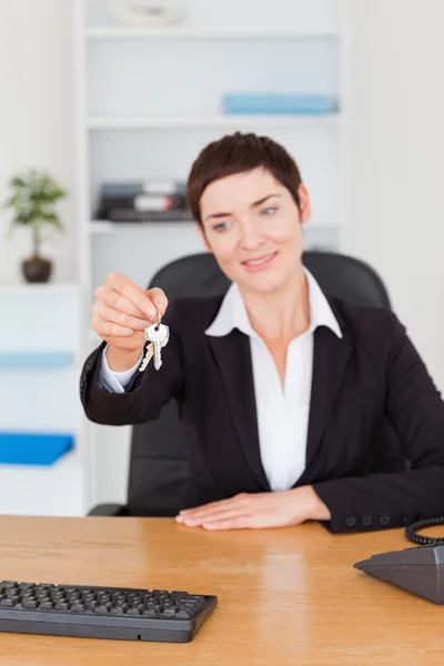 Retrato de um funcionário de escritório mostrando chaves — Fotografia de Stock
