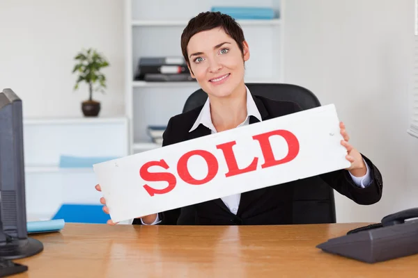 Agente imobiliário feliz com um painel vendido — Fotografia de Stock
