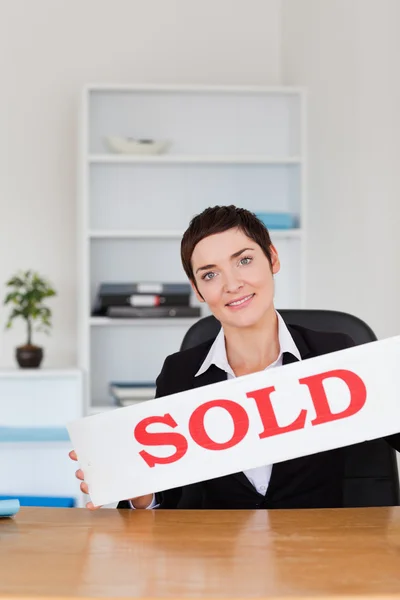 Retrato de un agente inmobiliario con un panel vendido — Foto de Stock