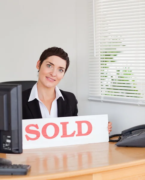 Charming real estate agent with a sold panel — Stock Photo, Image