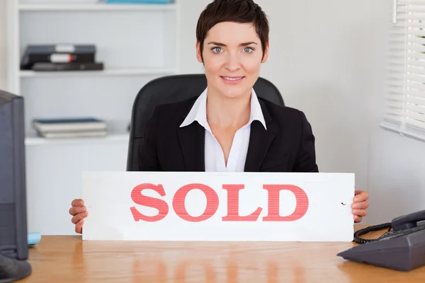 Linda agente de bienes raíces con un panel vendido — Foto de Stock