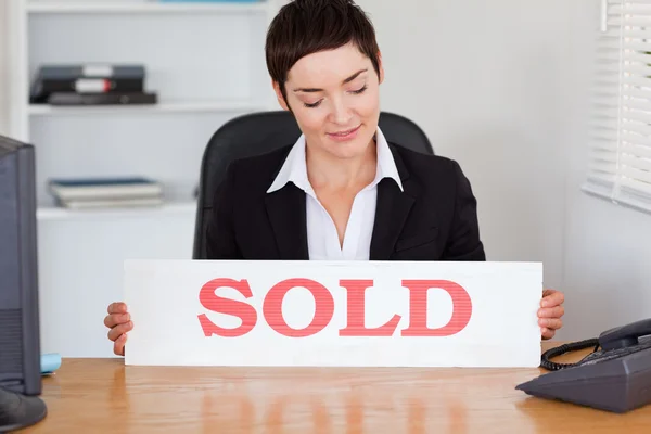Real estate agent looking at a sold panel — Stock Photo, Image