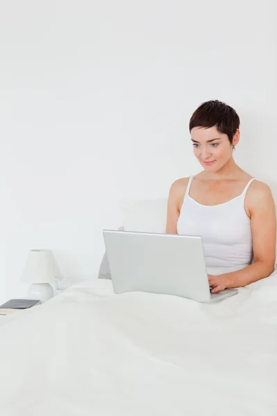 Portret van een brunette vrouw met behulp van een laptop — Stockfoto