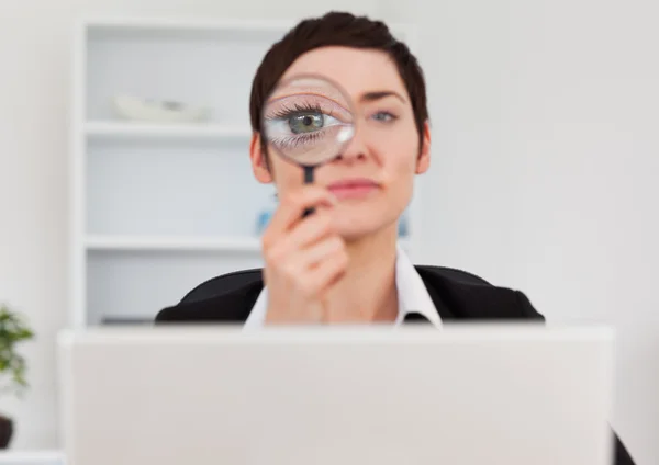 Trabalhador de escritório olhando através de uma lupa — Fotografia de Stock
