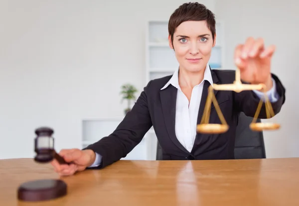 Serious woman with a gavel and the justice scale — Stock Photo, Image
