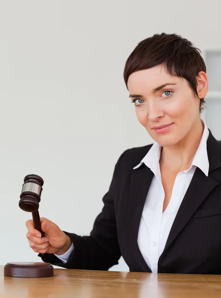 Portrait of a serious woman knocking a gavel — Stock Photo, Image