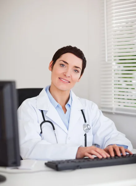 Portrait of a doctor typing with her computer — Stock Photo, Image