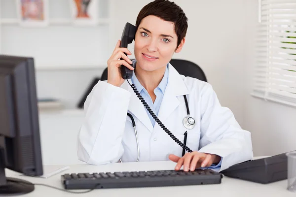 Médico sonriente haciendo una llamada telefónica — Foto de Stock