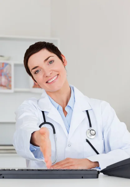 Female doctor giving her hand — Stock Photo, Image