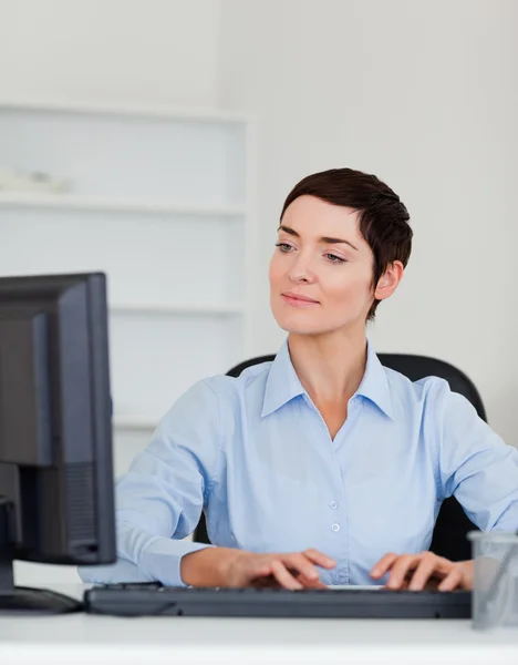 Retrato de una mujer de negocios seria escribiendo con su computadora — Foto de Stock