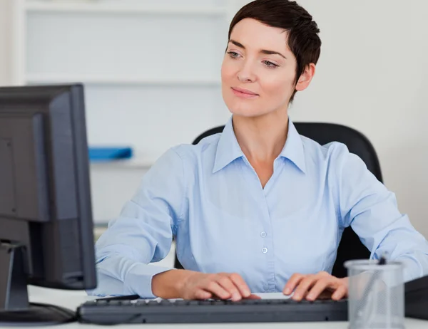 Nette Geschäftsfrau tippt mit ihrem Computer — Stockfoto