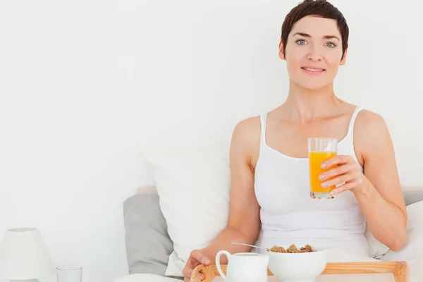 Närbild av en kvinna som dricker apelsinjuice — Stockfoto