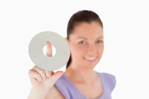 Attractive woman holding a CD while standing — Stock Photo, Image