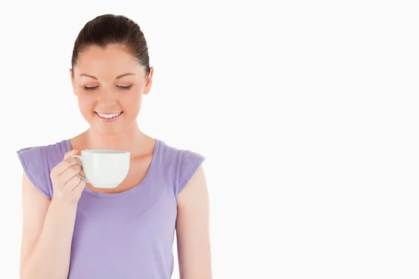 Прекрасна жінка насолоджується чашкою кави, стоячи — стокове фото