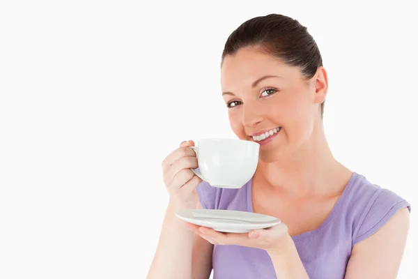 Cute woman enjoying a cup of coffee while standing — Stock Photo, Image