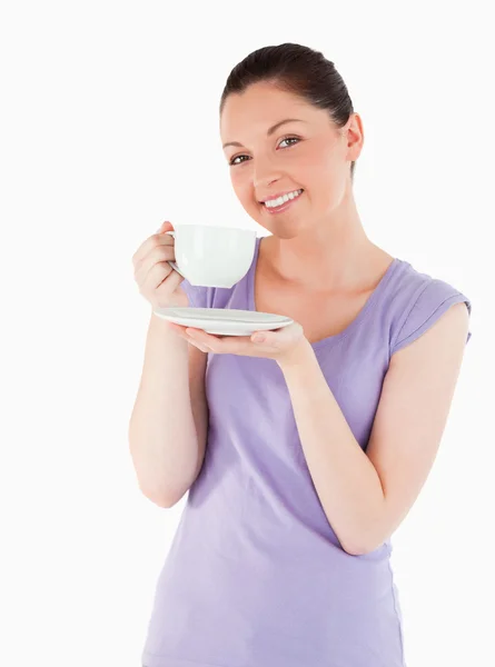 Чарівна жінка насолоджується чашкою кави, стоячи — стокове фото