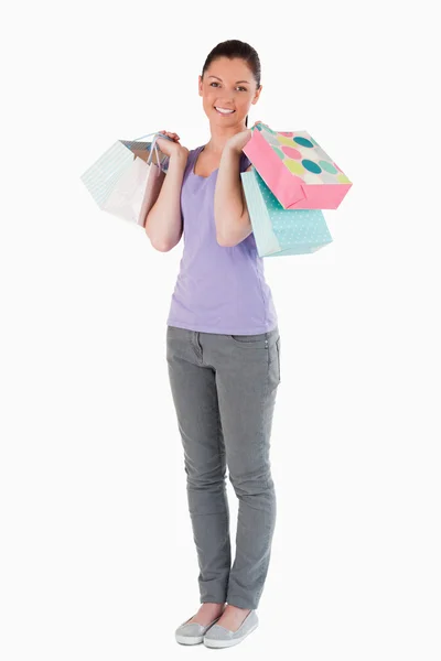 Mulher encantadora segurando sacos de compras enquanto está de pé — Fotografia de Stock