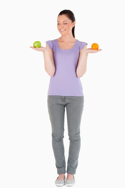 Attraktiv kvinna håller frukt stående — Stockfoto