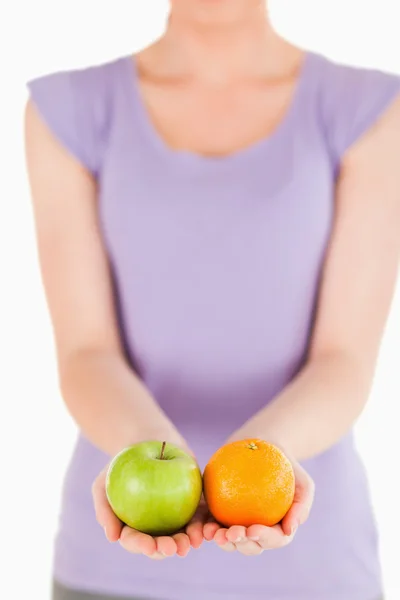 Young woman holding fruits while standing — Stock Photo, Image