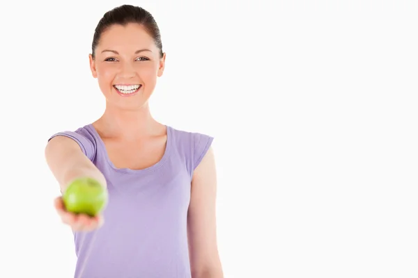 Gorgeous woman holding an apple while standing — Stock Photo, Image