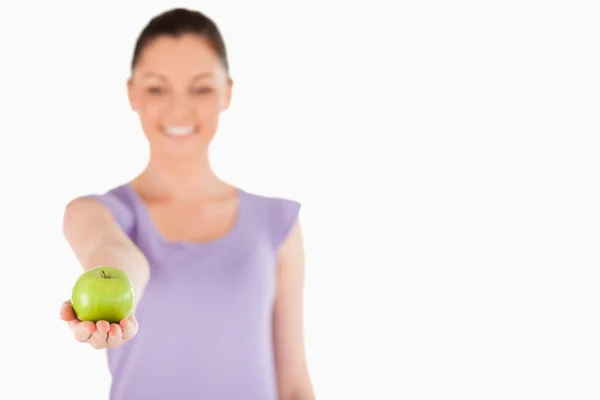 Bella donna in possesso di una mela mentre in piedi — Foto Stock