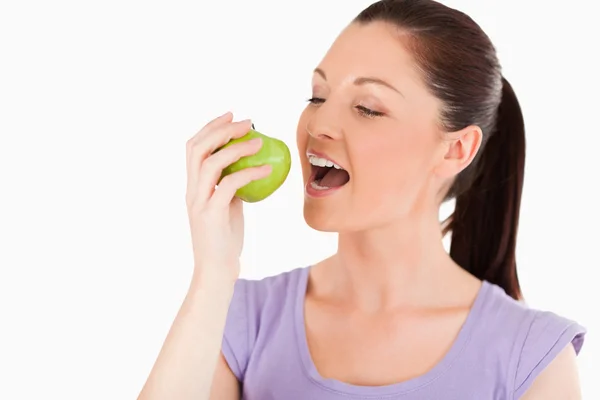 Mujer encantadora comiendo una manzana mientras está de pie —  Fotos de Stock