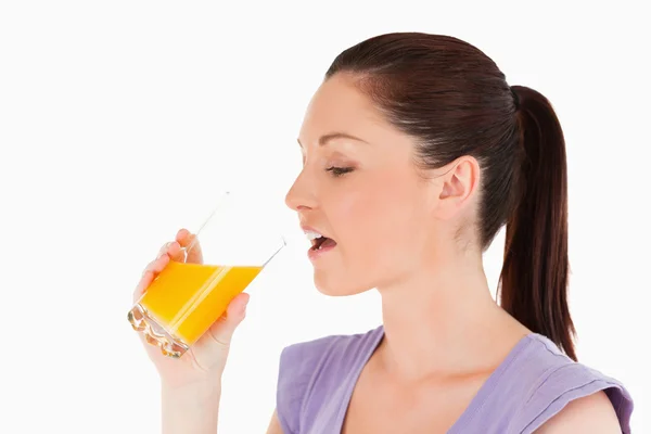 Belle femme buvant un verre de jus d'orange debout — Photo
