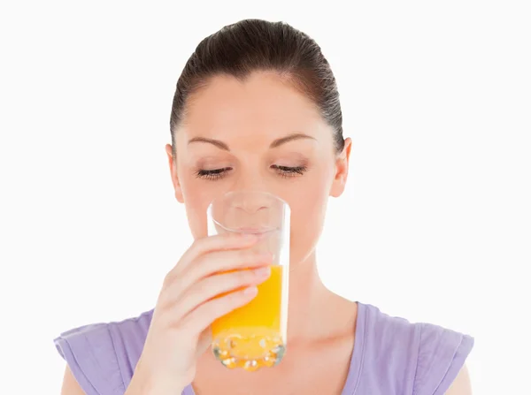 Dobra kobieta szuka picia szklankę soku pomarańczowego a szlifowane — Zdjęcie stockowe