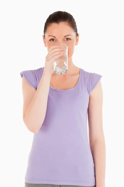 Charming woman drinking a glass of water while standing — Stock Photo, Image