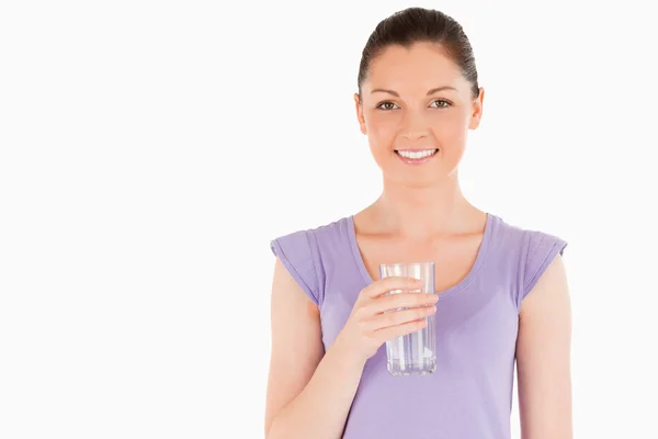 Mooie vrouw met een glas water terwijl staande — Stockfoto