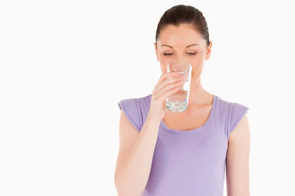 Piękna kobieta wypija szklankę wody stojąc — Zdjęcie stockowe