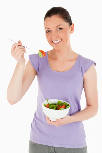 Atrakcyjna kobieta jedzenie miska sałatki stojąc — Zdjęcie stockowe