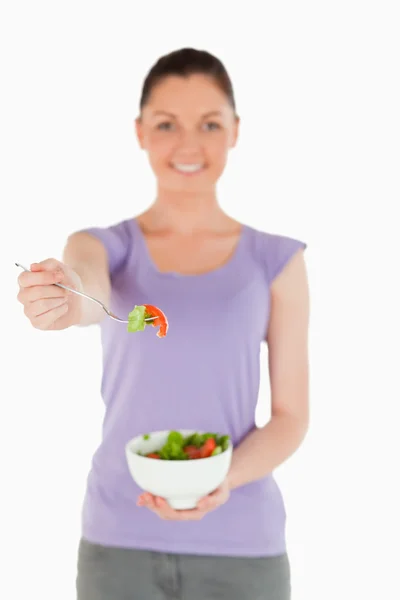 Goed ogende vrouw met een kom van salade terwijl staande — Stockfoto