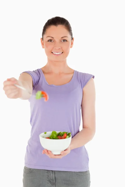 Приваблива жінка тримає тарілку салату, стоячи — стокове фото