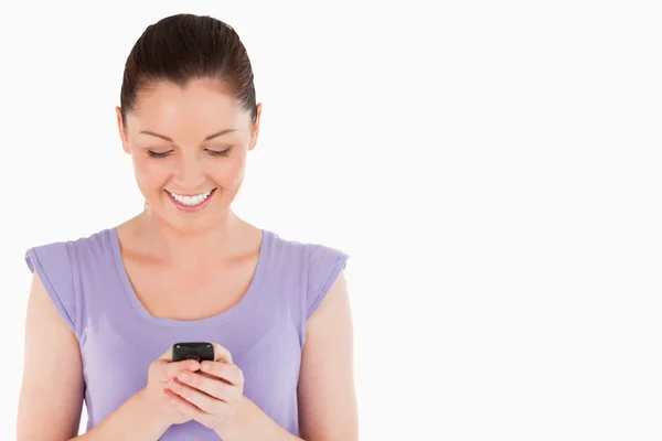 Härlig kvinna skriva en text på sin telefon stående — Stockfoto