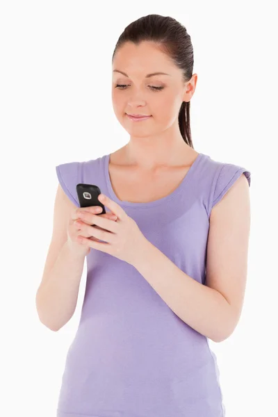Mulher bonita escrevendo um texto em seu telefone enquanto está de pé — Fotografia de Stock