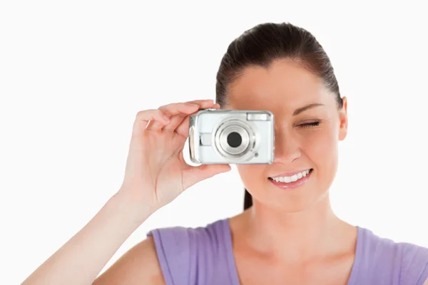 Portrait of a beautiful woman using a camera while standing — Stock Photo, Image