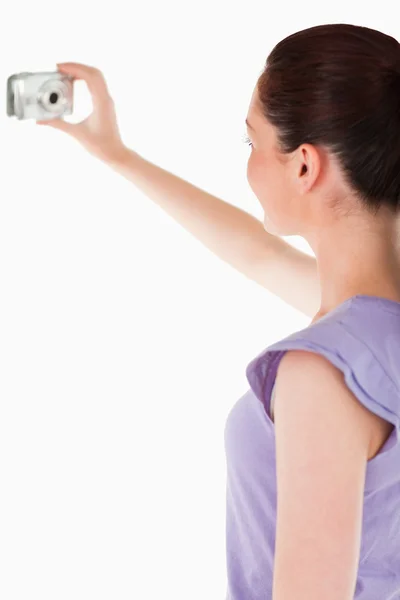 Charming woman using a camera while standing — Stock Photo, Image