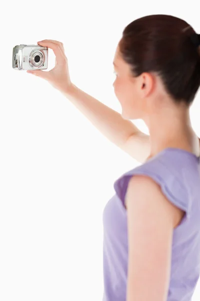 Lovely woman using a camera while standing — Stock Photo, Image