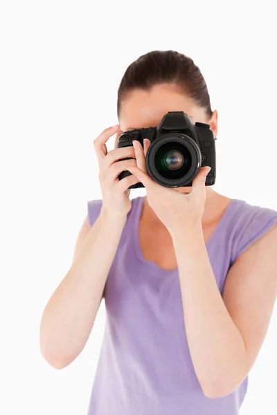 Charming female using a camera while standing — Stock Photo, Image