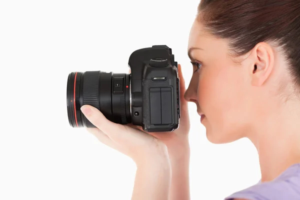 Mulher atraente usando uma câmera em pé — Fotografia de Stock