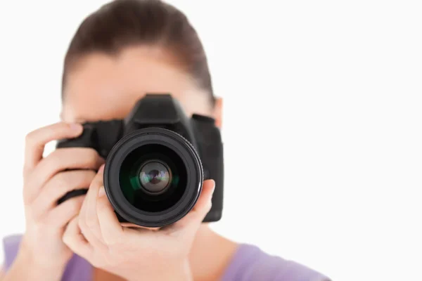 Good looking female using a camera while standing — Stock Photo, Image