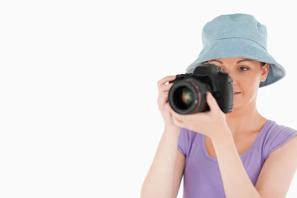 Lovely female using a camera while standing — Stock Photo, Image