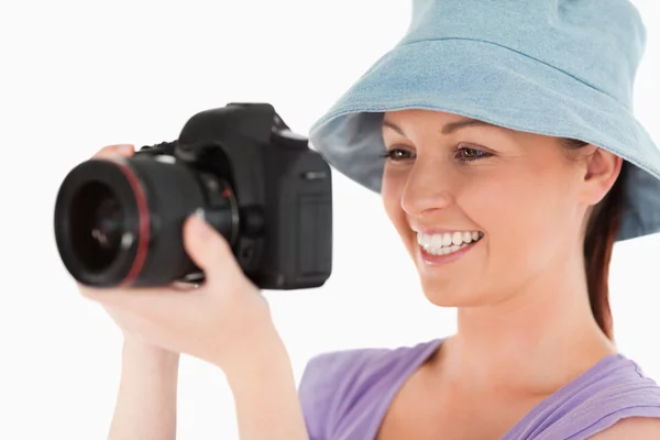 Cute vrouw met behulp van een camera terwijl staande — Stockfoto
