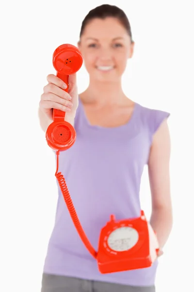 Atrakcyjna kobieta trzymając czerwony telefon stojąc — Zdjęcie stockowe