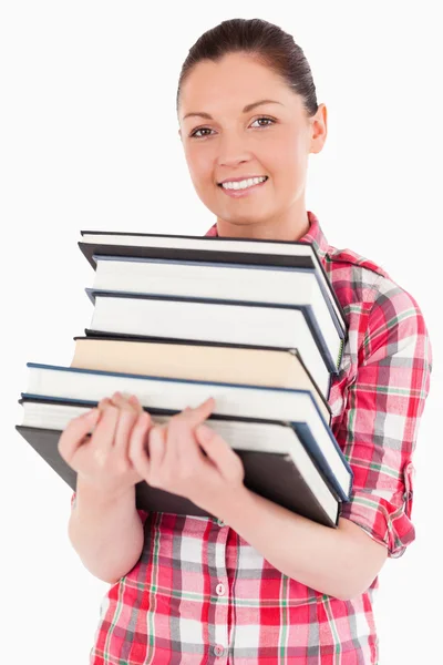 Affascinante femmina in posa con i libri mentre in piedi — Foto Stock