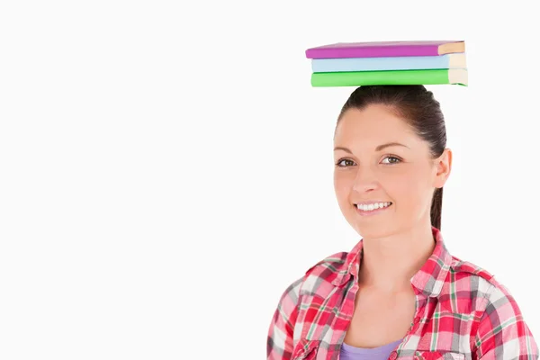 Splendidi libri femminili in possesso sulla sua testa mentre in piedi — Foto Stock