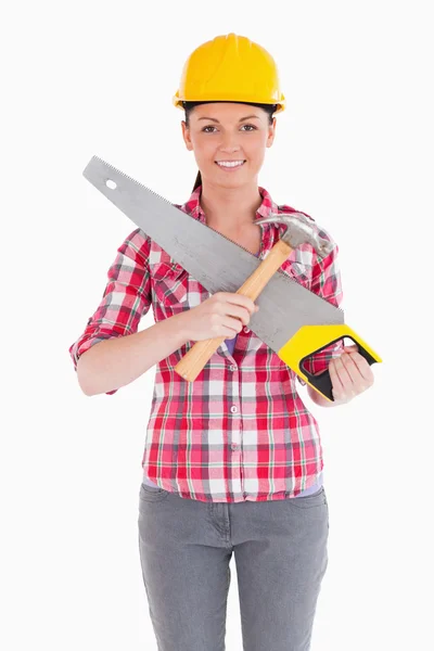 Pretty woman holding a saw while standing — Stock Photo, Image